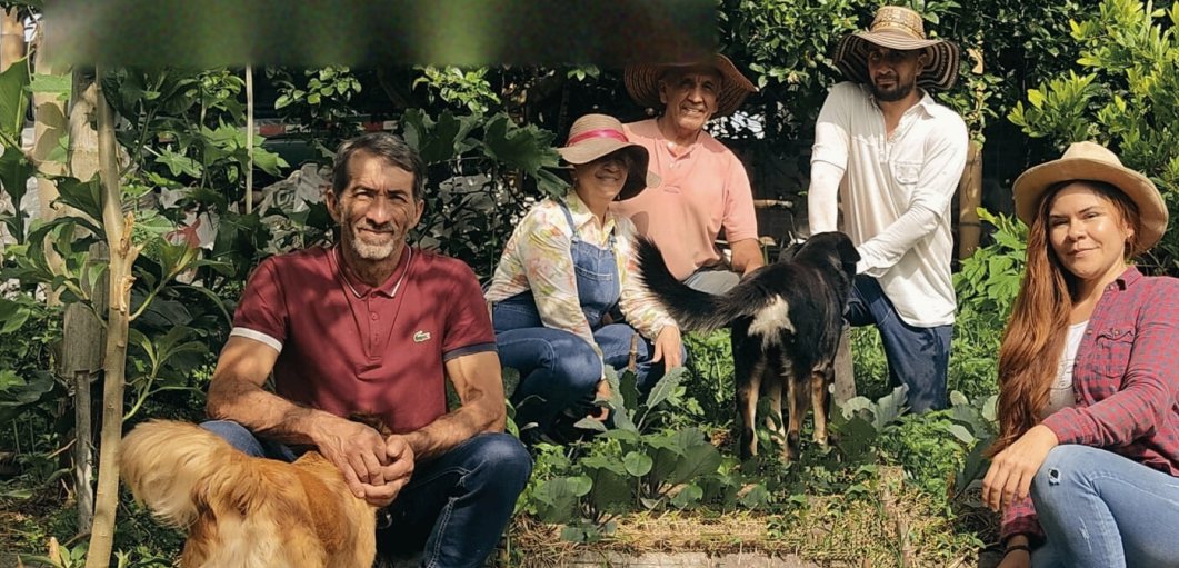 El equipo de Kundina en la huerta, con sombreros y sus perros